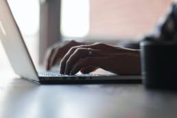 hands typing on laptop